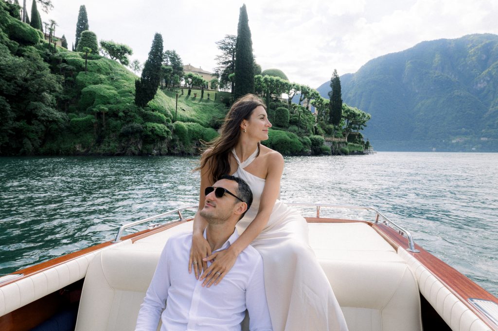 couple on a wooden boat in front of villa del balbianello during an engagement on lake como
