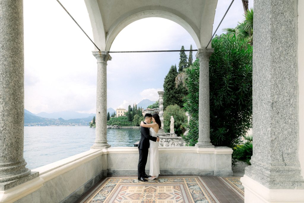 couple hugging in the loggia in the gardens of villa monastero in Varenna on lake como during the honeymoon