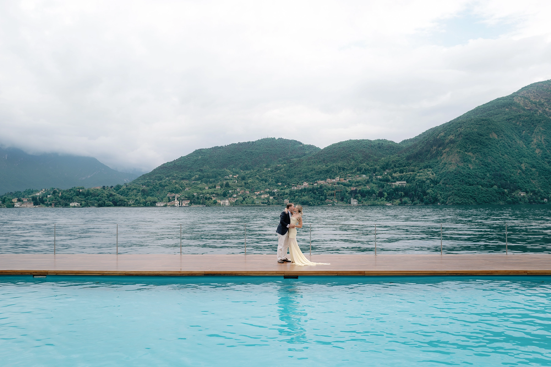 Candid moment of a couple at the Tremezzo T Beach pool with the Grigne mountains in the distance
