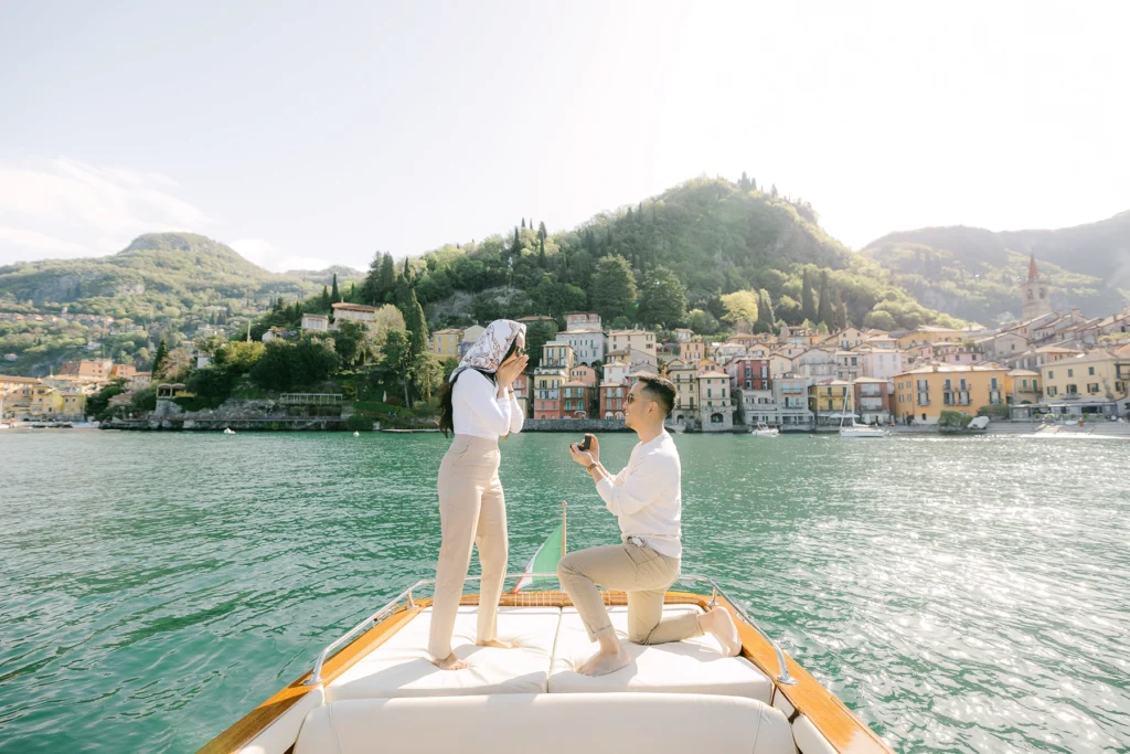 couple proposal photoshooting on a wooden boat in front of Varenna town on Lake Como