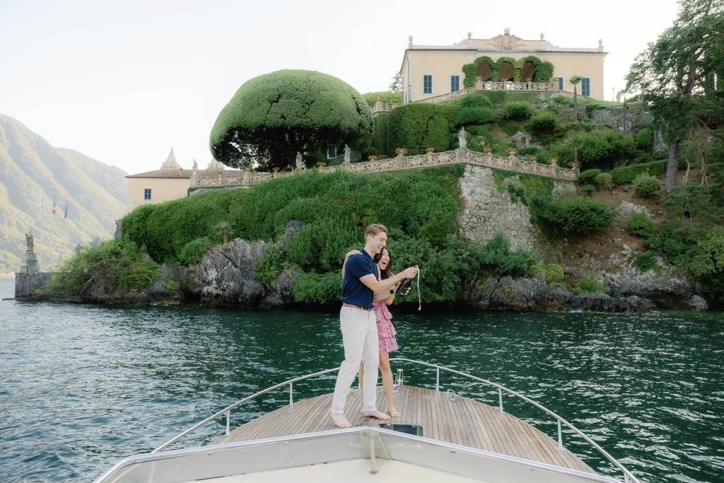 couple proposal photoshooting on a wooden boat in front of Villa del Balbianello on Lake Como