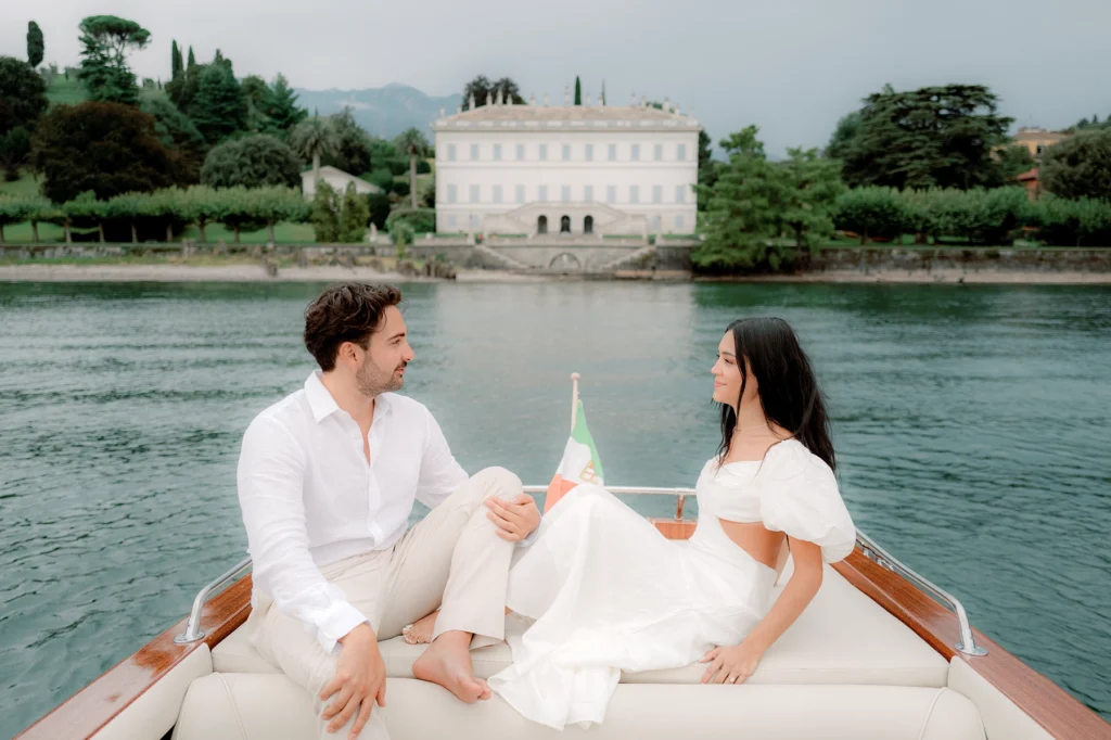 couple engagement photoshooting on a wooden boat in front of Villa Melzi on Lake Como